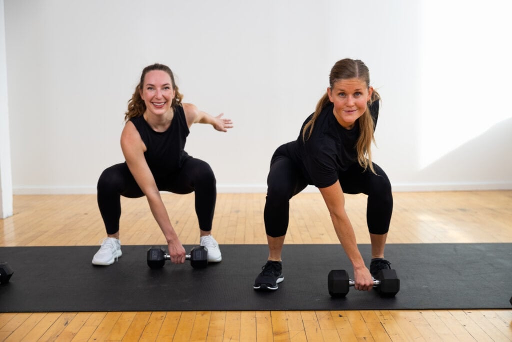 two women in a low squat as part of functional training workout