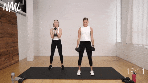 two women performing squats as part of chest and legs workout