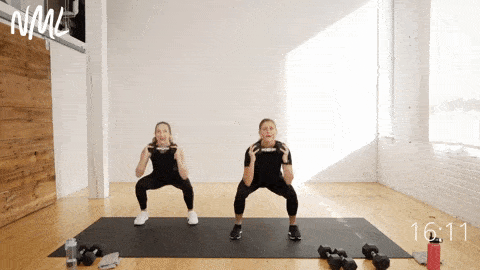 two women demonstrating two lateral side step squats and overhead tricep extensions as part of functional training workout