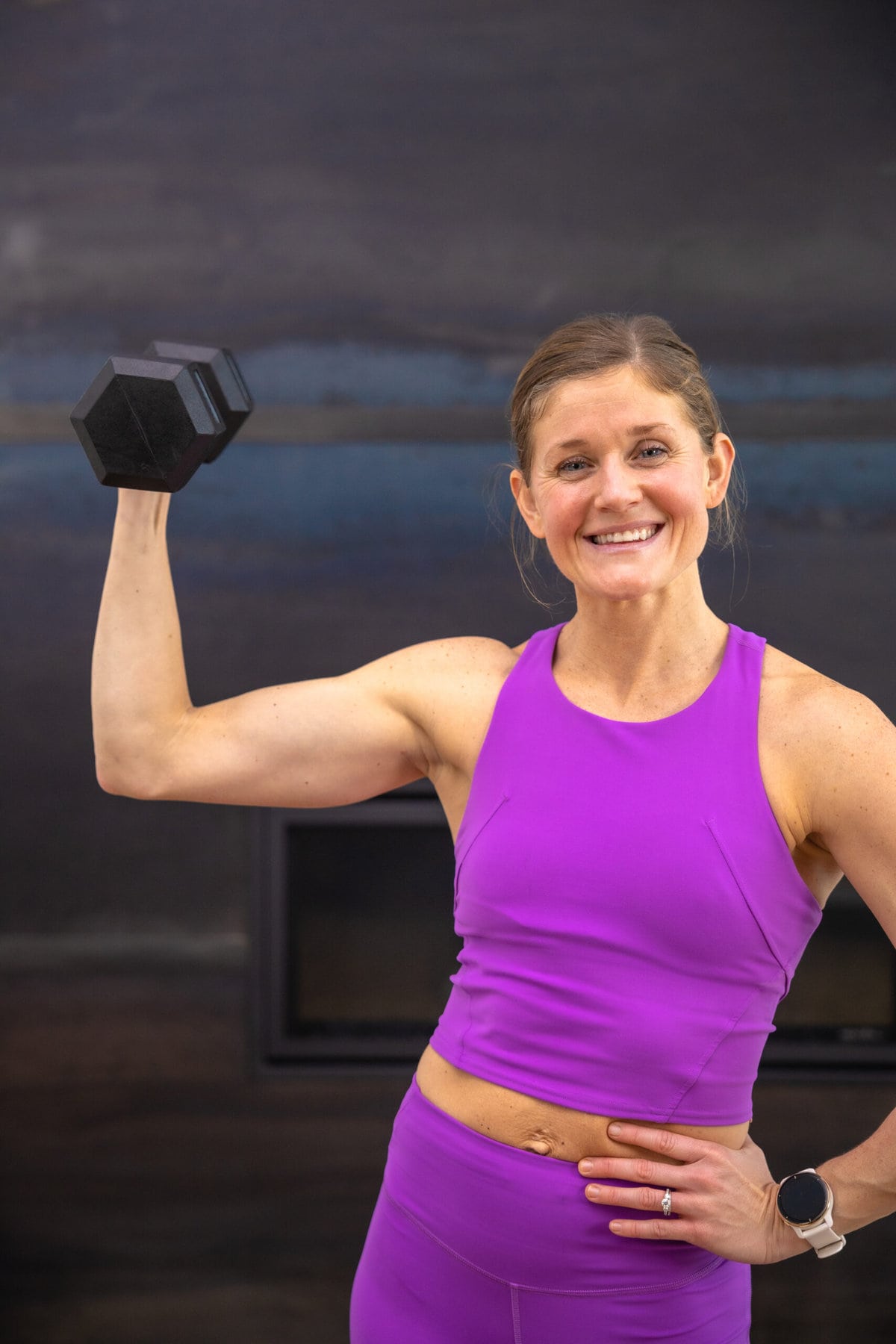 Muscular woman in gym showing back muscles. Strong fitness girl