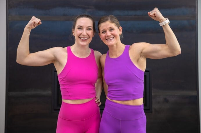 Two women performing a bicep flex as part of toned arms workout for women