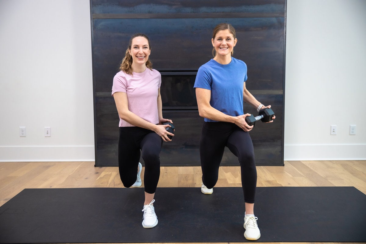 two women performing lunge as part of full body dumbbell workout