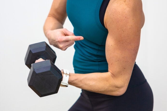 Woman curling a dumbbell towards her shoulder as part of bicep workout