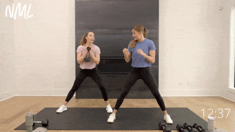 two women performing lateral squats as part of dumbbell strength training workout