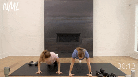 two women performing stack on push ups and a plank hold as part of dumbbell strength training workout