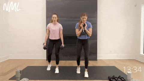 two women performing staggered squat as part of dumbbell strength training