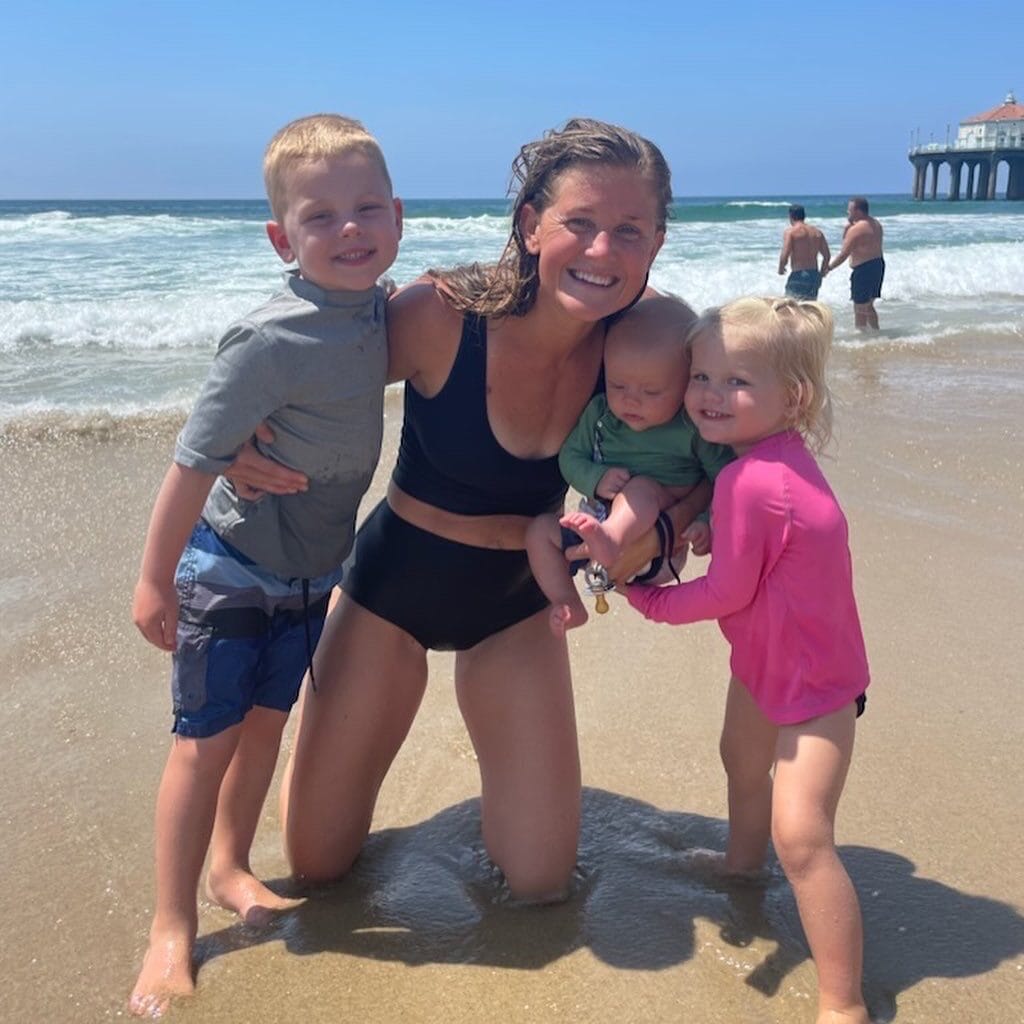 Fit mom of 3 littles on a beach swimming