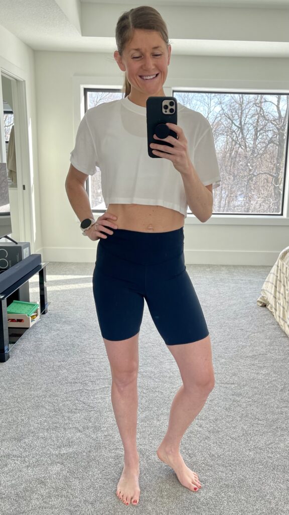 Woman posing in base pace biker shorts in front of mirror 