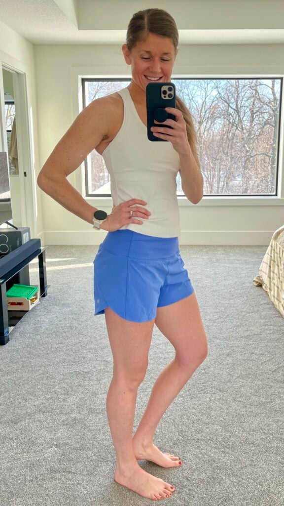 Woman posing in mirror wearing lululemon speed up shorts as part of lululemon shorts review