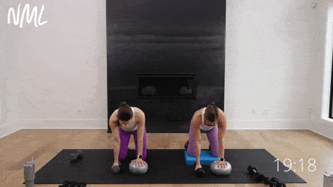 two women performing a quadruped single arm back row balancing one hand on a pilates ball in a pilates class at home