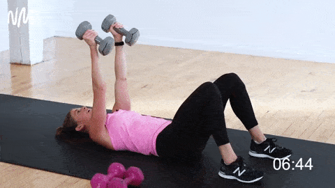 woman performing dumbbell skull crushers in a total body workout