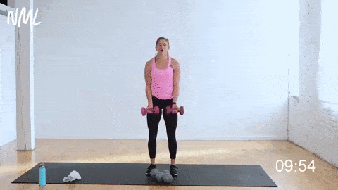 woman performing a wide bicep curl and lateral raise in a total body strength workout no repeats