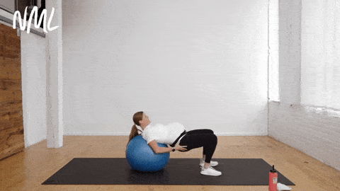 pregnant woman performing glute bridges with her upper back on an exercise ball