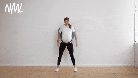 pregnant woman performing supported squats with birthing ball as example of pregnancy ball exercise