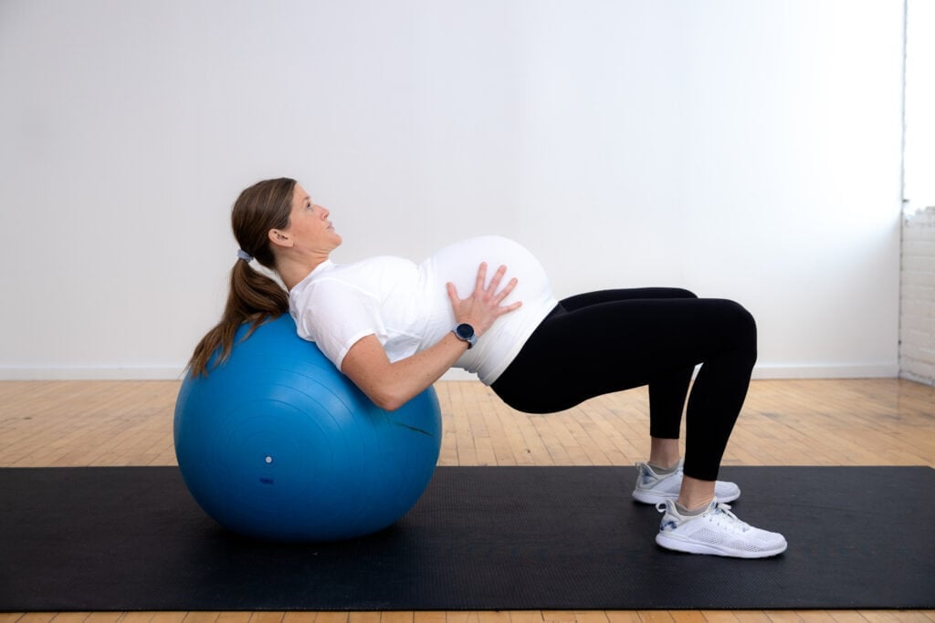 pregnant woman performing glute bridge on a birthing ball as example of pregnancy ball exercises