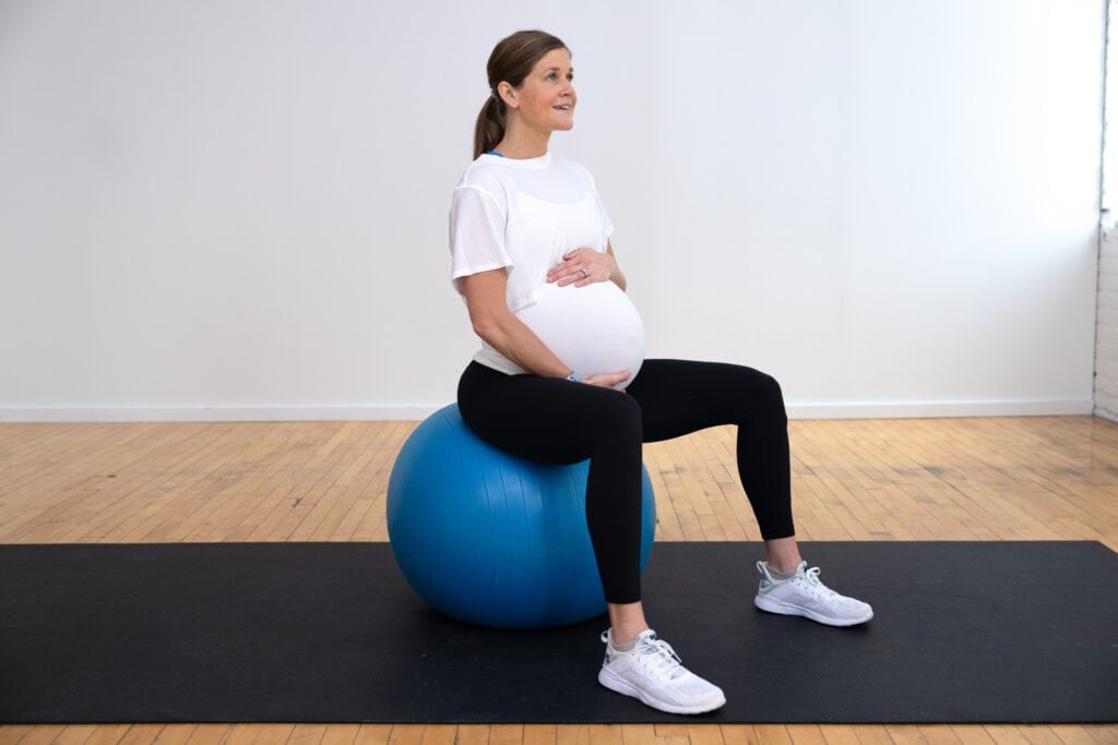 woman sitting on a birthing ball as part of best pregnancy ball exercises workout