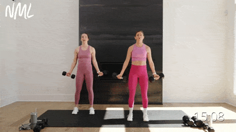 two women performing standard bicep curls with dumbbells in a full body emom workout