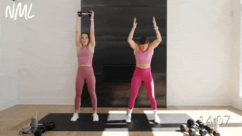 one woman performing burpees and one woman performing a dumbbell squat and press out and overhead press in a full body strength and cardio workout