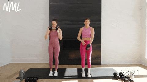 two women performing a reverse lunge and dumbbell handswitch in a total body strength and HIIT emom workout at home