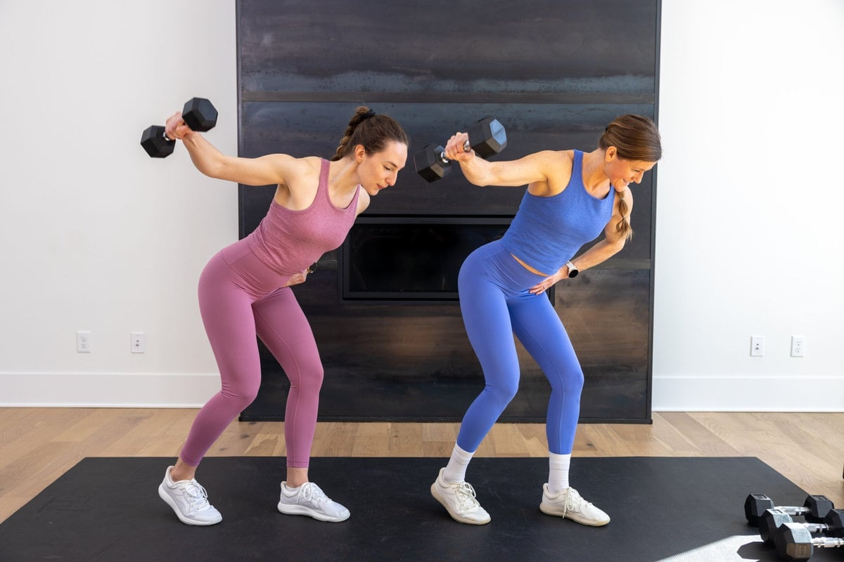 two women performing single arm back flys with dumbbells as example of best back exercises for women