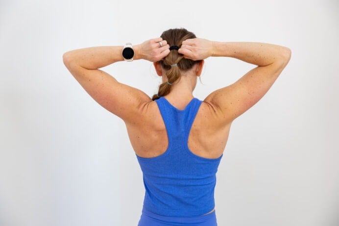 woman flexing her back as part of back workout for women workout post