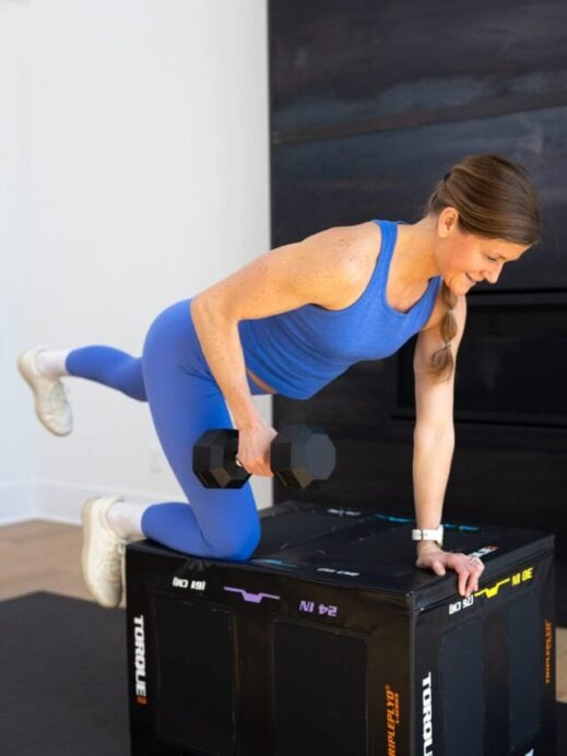 back exercises for women - woman performing a single arm back row on a box