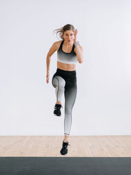 Woman performing a plyo lunge as part of single dumbbell workout