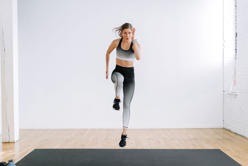 Woman performing a plyo lunge as part of single dumbbell workout