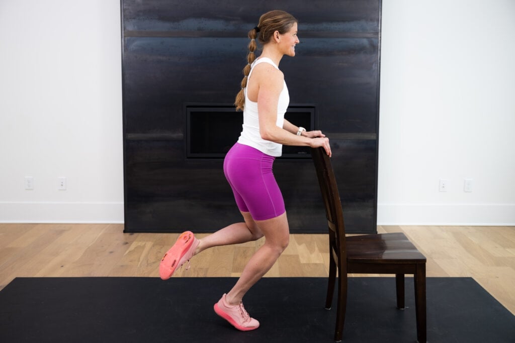 Woman performing a single leg calf raise as example of best calf exercises