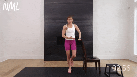 Woman performing single leg calf raises as part of calf workout at home