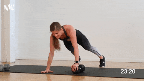 woman performing uneven push up and shoulder tap as part of single dumbbell workout