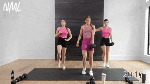 three women performing a lateral lunge with a dumbbell in a lower body strength workout