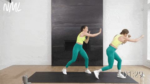 two women performing a lateral shuffle and press across in a standing cardio workout to burn fat