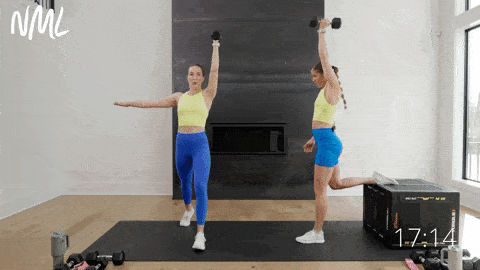 one woman performing a rear foot elevated lunge and single arm press, another woman performing a split lunge and single arm overhead press in a home workout