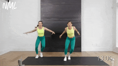 two women performing a side to side step touch in a standing cardio workout at home