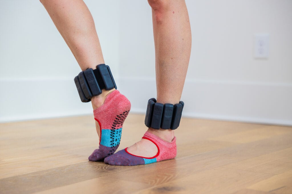 close up image of woman wearing ankle weights as part of ankle weights workout