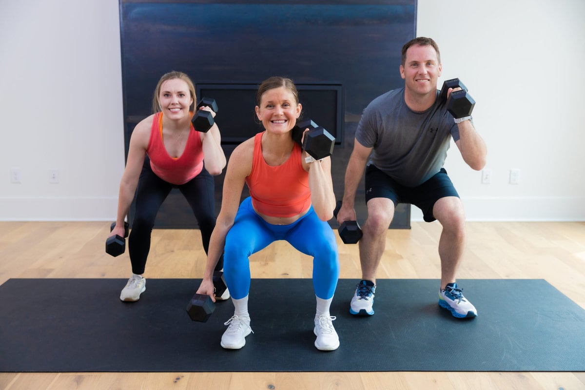 three people performing an uneven rack front squat as part of cardio and strength training workout