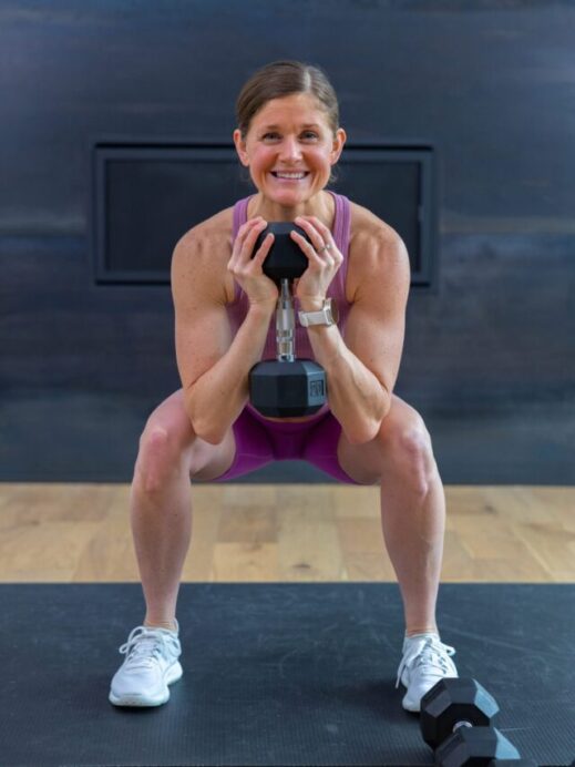 woman performing a goblet squat in a lower body strength workout