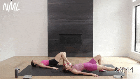 two women performing a single leg glute bridge with a leg lower as example of ankle weight exercises