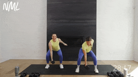 two women performing a low squat with a squat pulse as part of lower body dumbbell workout