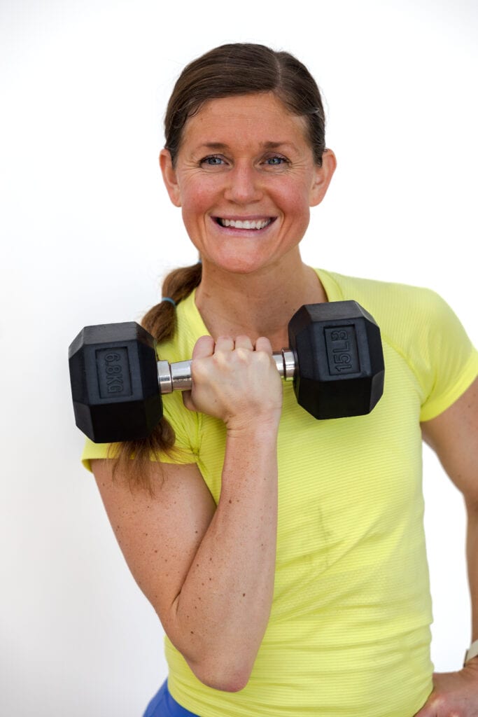 Woman holding a front racked dumbbell as part of lower body dumbbell workout