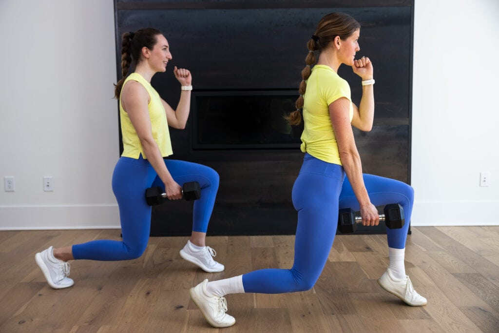 two women performing a lunge with a calf raise as part of lower body dumbbell workout