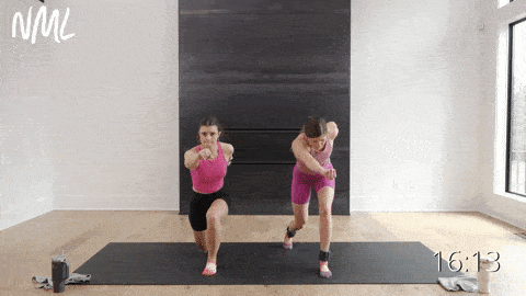 two women performing a reverse lunge and cross body punch while wearing ankle weights
