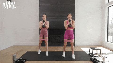 two women performing an 80/20 banded goblet squat in a home leg workout