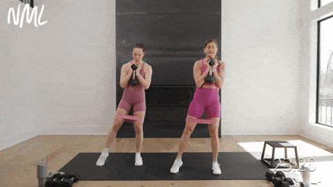 two women performing an 80/20 banded runner squat and lateral tap in a leg workout