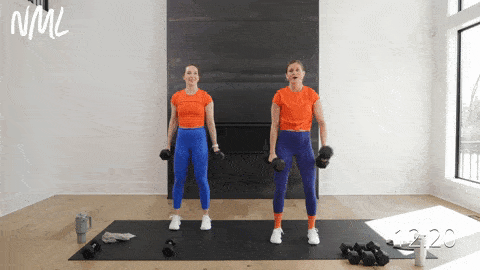 two women performing alternating dumbbell bicep curls with heavy dumbbells in a pull workout at home