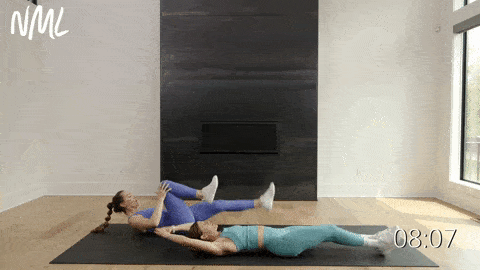 one woman performing an alternating knee pull into a straight leg pull and one woman performing alternating knee pulls in an ab workout at home