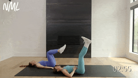 two women performing double alternating leg lowers in an ab workout at home