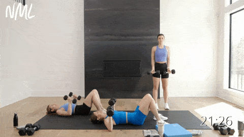 two women performing a dumbbell chest press and one woman performing a standing dumbbell chest fly in an upper body strength workout