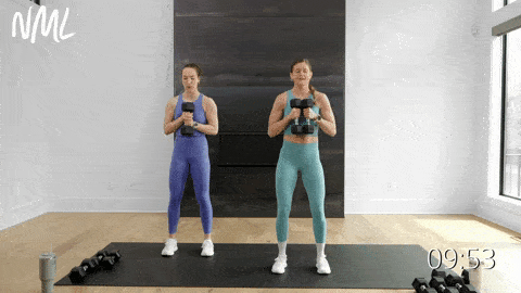 two women performing a dumbbell svend press in a chest workout at home